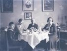 A. M. Schoss: hosté u stolu (černobílý negativ)