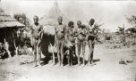 Muž a ženy s dětmi před hliněnou sýpkou, Kumam nebo Teso