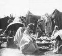 Ženy na tržišti s mísami pokrytými pletenými poklopy