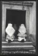 Ženy, klečící ve dveřích do kostela, pohled zezadu do kostela