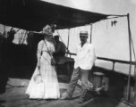 B.Machulka s neznámou ženou v evropských šatech a s domorodým vějířem ve tvaru praporku stojí na palubě lodi