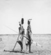 Dva stojící muži v přehozech přes rameno, s tanečními oštěpy, Dinkové