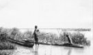 Dva muži v člunech dlabaných z jednoho kusu dřeva u břehu řeky, kmen Bari