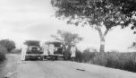 Dvě auta Machulkovy výpravy vedle sebe na silnici s členy výpravy, Albertovo jezero