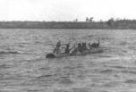 Muži v člunu se plaví přes řeku